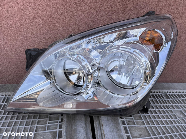 Lampa przednia OPEL ASTRA III H LIFT LEWA EUROPA ORYGINALNA HELLA