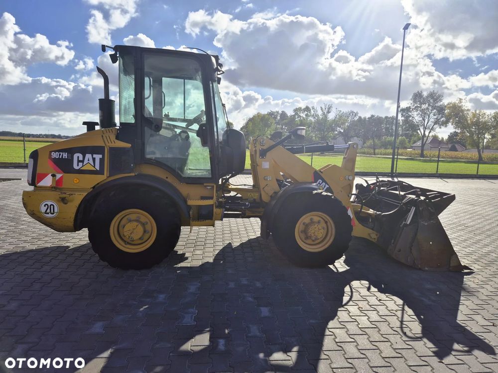 Caterpillar 907H / z Niemiec / Łyżka otwierana + Widły / 6700 mth / - 5
