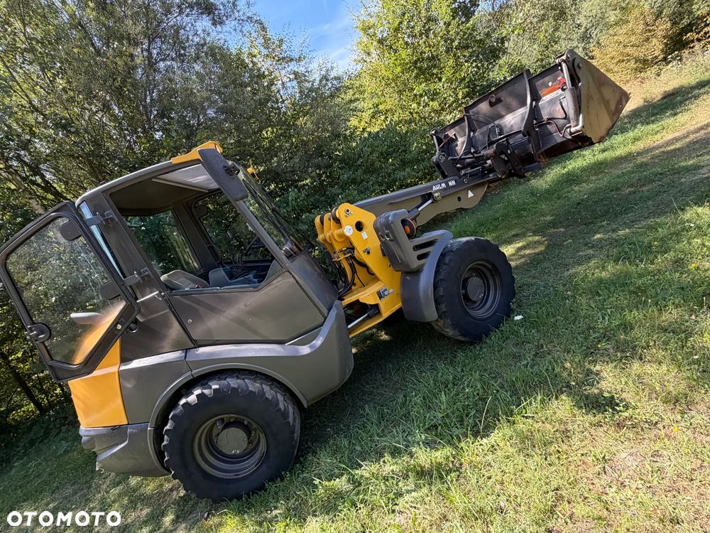Mecalac AX1000 Ładowarka kołowa łamana 6,5 tony. Udźwig około 3 tony. 2017 rok.  Jak Nowa! Oryginał łyżka KROKODYL otwierana i widły. Mocny silnik DEUTZ 4 cylindry DEUTZ. Zero luzów i wycieków. Aktualne Badania DEKRA BMWT. Wielka Okazja. Maszyna jak nowa z Salonu. 2900 mtg. Pochodzi z Norweskiego urzędu gminy. Dodatkowe linie Hydrauliczne. Szybka wolna Jazda Rewers Hydrostatic. Wersja Norweska Mocne doświetlenie dodatkowe grzanie. kabina Ogrzewana wentylowana! Zmiana Osprzętu Hydrauliczna! pełne sterowanie z dżojstika! Podzespoły pompy suche, czytelne tabliczki! OKAZJA - 3