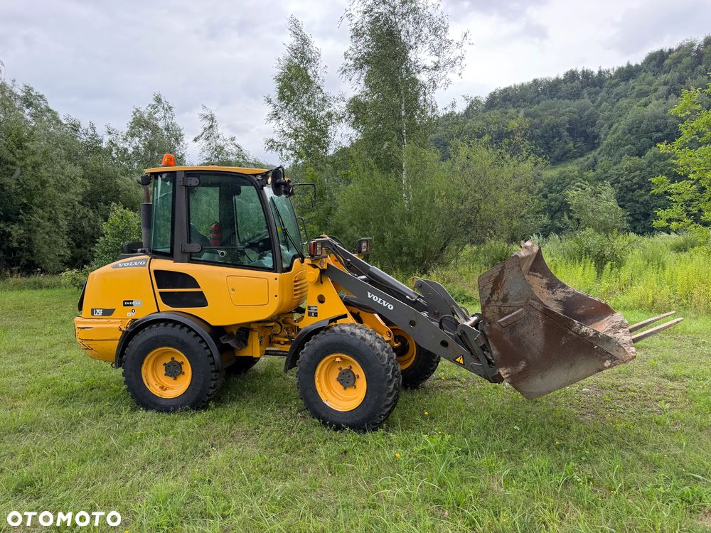 Volvo L25F Ładowarka Kołowa łamana 2015 rok. Jak Nowa! Oryginał łyżka i widły. Mocny silnik 4 cylindry. Zero luzów i wycieków. Aktualne Badania DEKRA BMWT. Wielka Okazja. Maszyna jak nowa z Salonu. 2600 mtg. Pochodzi z Norweskiego urzędu gminy. Dodatkowe linie Hydrauliczne. Szybka wolna Jazda Rewers Hydrostatic. Wersja Norwesk Mocne doświetlenie dodatkowe grzanie. kabina Ogrzewana wentylowana! Zmiana Osprzętu Hydrauliczna! pełne sterowanie z dżojstika! Opony jak Nowe. Podzespoły pomy suche, czytelne tabliczki! OKAZJA - 1