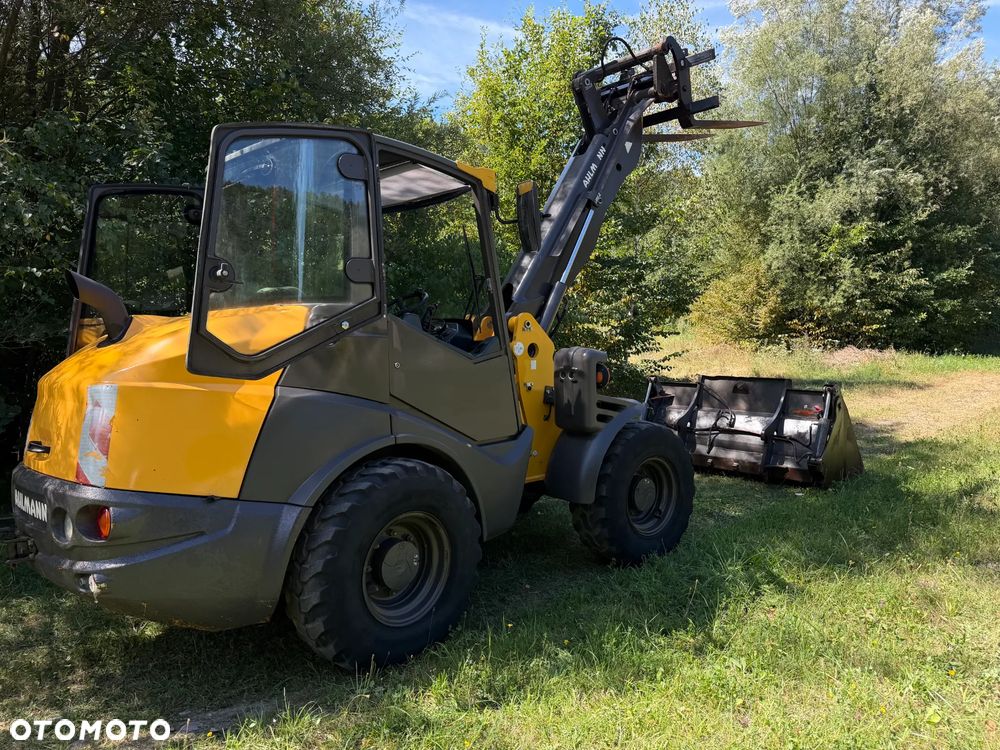 Mecalac AX1000 Ładowarka kołowa łamana 6,5 tony. Udźwig około 3 tony. 2017 rok.  Jak Nowa! Oryginał łyżka KROKODYL otwierana i widły. Mocny silnik DEUTZ 4 cylindry DEUTZ. Zero luzów i wycieków. Aktualne Badania DEKRA BMWT. Wielka Okazja. Maszyna jak nowa z Salonu. 2900 mtg. Pochodzi z Norweskiego urzędu gminy. Dodatkowe linie Hydrauliczne. Szybka wolna Jazda Rewers Hydrostatic. Wersja Norweska Mocne doświetlenie dodatkowe grzanie. kabina Ogrzewana wentylowana! Zmiana Osprzętu Hydrauliczna! pełne sterowanie z dżojstika! Podzespoły pompy suche, czytelne tabliczki! OKAZJA - 14