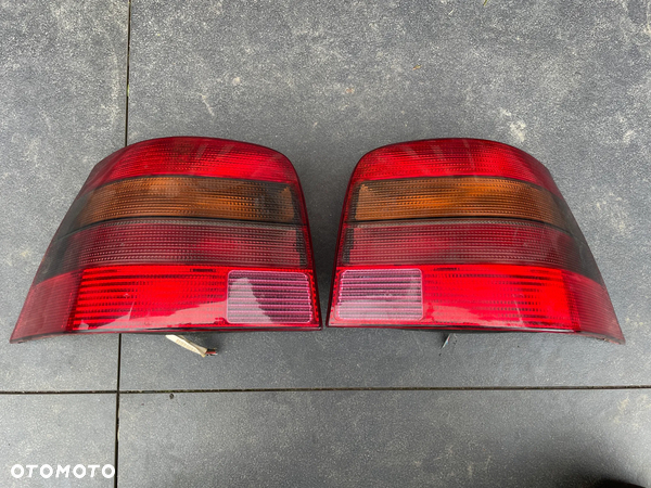 VW GOLF IV LAMPA LEWA PRAWA HELLA CIEMNE DYMIONE TYŁ ORYGINAŁ HB 3/5D komplet