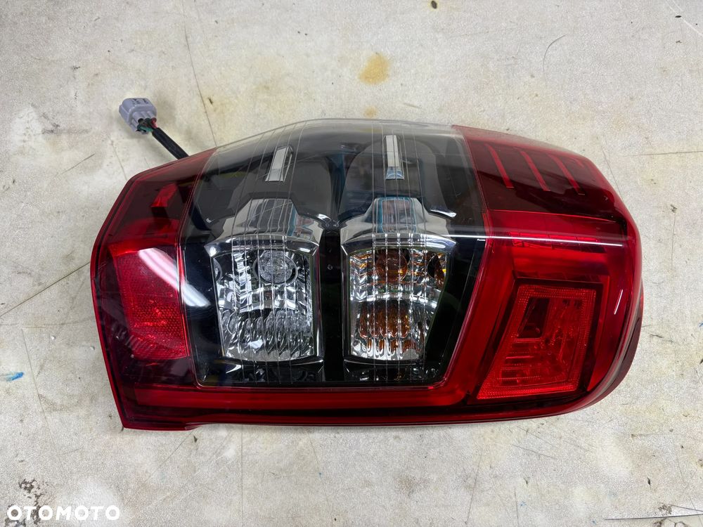 Lampa / reflektor Mitsubishi L200 Lift Nowy Model lewy tył (ORYGINALNE)