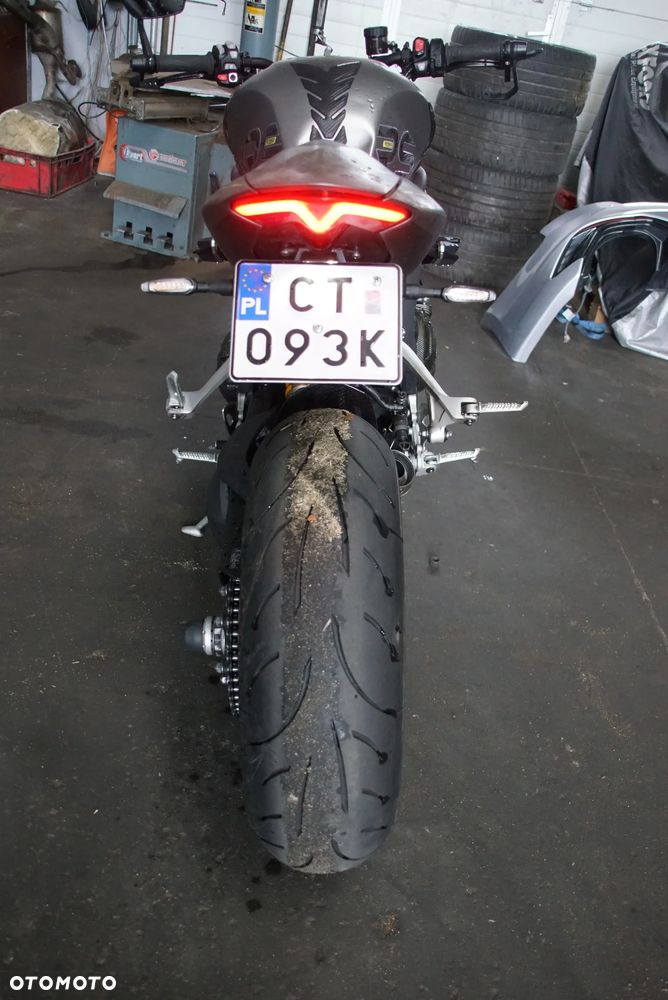 Triumph Speed Triple 1200 rs 2022 na części 692106889 SILNIK: silnik kompletny, blok silnika, głowica cylindrów, pokrywa zaworów, uszczelka głowicy, cylinder, tuleja cylindra, tłok, pierścienie tłokowe, sworzeń tłoka, korbowód, wał korbowy, panewki wału, wałek rozrządu, koło rozrządu, łańcuch rozrządu, napinacz rozrządu, ślizg rozrządu, zawór ssący, zawór wydechowy, sprężyna zaworowa, popychacz zaworu, dźwigienka zaworowa, uszczelniacz zaworowy, miska olejowa, korek spustowy oleju, pompa oleju, smok olejowy, filtr oleju, chłodnica oleju, przewód olejowy, obudowa filtra oleju, czujnik ciśnienia oleju, pokrywa alternatora, pokrywa sprzęgła, dekiel silnika, uszczelki silnika, engine assembly, engine block, cylinder head, valve cover, piston, piston rings, connecting rod, crankshaft, camshaft, timing chain, oil pump.  UKŁAD PALIWOWY I DOLOTOWY: zbiornik paliwa, bak paliwa, korek wlewu paliwa, pompa paliwa, kosz pompy paliwa, filtr paliwa, przewód paliwowy, listwa wtryskowa, wtryskiwacz, regulator ciśnienia paliwa, przepustnica, korpus przepustnicy, silniczek krokowy, czujnik położenia przepustnicy TPS, manetka gazu, rolgaz, elektroniczny gaz ride-by-wire, airbox, obudowa filtra powietrza, filtr powietrza, króciec dolotowy, kolektor dolotowy, czujnik temperatury powietrza, czujnik ciśnienia MAP, fuel tank, fuel pump, fuel injector, throttle body, air filter.  SPRZĘGŁO I SKRZYNIA BIEGÓW: kosz sprzęgłowy, piasta sprzęgła, tarcze sprzęgłowe, przekładki sprzęgła, sprężyny sprzęgła, docisk sprzęgła, pompa sprzęgła, wysprzęglik, przewód sprzęgła, klamka sprzęgła, skrzynia biegów, wałek sprzęgłowy, wałek zdawczy, koła zębate skrzyni, wodzik zmiany biegów, bęben zmiany biegów, czujnik biegu, dźwignia zmiany biegów, cięgno zmiany biegów, quickshifter, czujnik quickshiftera, clutch basket, clutch plates, gearbox, transmission shaft, gear selector drum, shift fork.  NAPĘD TYLNEGO KOŁA: zębatka przednia, zębatka tylna, łańcuch napędowy, spinka łańcucha, napinacz łańcucha, prowadnica łańcucha, osłona łańcucha, guma zabieraka, zabierak zębatki, mocowanie zębatki, front sprocket, rear sprocket, drive chain, chain adjuster, chain guide, chain guard, sprocket carrier.  UKŁAD WYDECHOWY: kolektory wydechowe, rury wydechowe, tłumik końcowy, tłumik środkowy, katalizator, osłona tłumika, zawór wydechowy, silniczek zaworu wydechowego, linki zaworu wydechowego, sonda lambda, uszczelka kolektora, obejma wydechu, mocowanie tłumika, exhaust headers, muffler, silencer, catalytic converter, exhaust valve, oxygen sensor, heat shield.  UKŁAD CHŁODZENIA: chłodnica, wentylator chłodnicy, osłona chłodnicy, korek chłodnicy, zbiorniczek wyrównawczy, pompa wody, termostat, obudowa termostatu, przewód chłodnicy, wąż układu chłodzenia, króciec wody, czujnik temperatury płynu, radiator, radiator fan, coolant reservoir, water pump, thermostat, coolant hose.  ZAWIESZENIE PRZEDNIE: lagi przednie, widelec przedni, goleń widelca, rura nośna, dolna półka, górna półka, sztyca widelca, uszczelniacz lagi, uszczelniacz przeciwpyłowy, sprężyna widelca, kartridż amortyzatora, regulator tłumienia, korek lagi, olej do lag, amortyzator skrętu, steering damper, front fork, fork tube, fork seal, fork cartridge, triple clamp, upper yoke, lower yoke.  ZAWIESZENIE TYLNE: amortyzator tylny, sprężyna amortyzatora, wahacz jednoramienny, oś wahacza, łożysko wahacza, kiwak zawieszenia, łącznik amortyzatora, regulator napięcia wstępnego, mocowanie amortyzatora, rear shock, shock absorber, single-sided swingarm, swingarm pivot, suspension linkage.  UKŁAD HAMULCOWY: zacisk hamulcowy przedni lewy, zacisk hamulcowy przedni prawy, zacisk hamulcowy tylny, jarzmo zacisku, tłoczek hamulcowy, zestaw naprawczy zacisku, klocki hamulcowe przednie, klocki hamulcowe tylne, tarcza hamulcowa przednia, tarcza hamulcowa tylna, pompa hamulcowa przednia, pompa hamulcowa tylna, przewód hamulcowy, przewód w oplocie, zbiorniczek płynu hamulcowego, klamka hamulca, pedał hamulca, czujnik światła stop, moduł ABS, pompa ABS, czujnik ABS, pierścień ABS, front brake caliper, rear brake caliper, brake pads, brake disc, brake rotor, brake master cylinder.  KOŁA I OPONY: felga przednia, felga tylna, koło przednie, koło tylne, oś koła przedniego, oś koła tylnego, dystans koła, łożysko koła, uszczelniacz koła, piasta koła, nakrętka tylnego koła, zawór opony, czujnik ciśnienia TPMS, opona przednia, opona tylna, front wheel, rear wheel, wheel rim, wheel axle, wheel bearing, wheel hub, tire, tyre, TPMS sensor.  KIEROWNICA I STEROWANIE: kierownica, mocowanie kierownicy, riser kierownicy, lewa manetka, prawa manetka, ciężarki kierownicy, końcówki kierownicy, lusterko lewe, lusterko prawe, uchwyt lusterka, klamka sprzęgła, klamka hamulca, przełącznik zespolony lewy, przełącznik zespolony prawy, rolgaz, stacyjka, antena stacyjki, amortyzator skrętu, handlebar, handlebar clamp, grip, bar end, rear-view mirror, switchgear, ignition switch.  RAMA I PODWOZIE: rama główna, rama tylna, subframe, wspornik ramy, mocowanie silnika, śruba mocowania silnika, crash pad, slider ramy, osłona ramy, stopka boczna, czujnik stopki bocznej, sprężyna stopki, uchwyt tablicy rejestracyjnej, mocowanie podnóżka, podnóżek kierowcy lewy, podnóżek kierowcy prawy, podnóżek pasażera lewy, podnóżek pasażera prawy, set podnóżków, rearset, frame, rear subframe, engine mount, crash protector, side stand, footpeg.  OWIEWKI I NADWOZIE: owiewka przednia, owiewka boczna lewa, owiewka boczna prawa, owiewka tylna, boczek lewy, boczek prawy, osłona chłodnicy, osłona silnika, belly pan, pług pod silnik, błotnik przedni, błotnik tylny, nadkole, hugger, przednia szyba, szyba sportowa, deflektor, wlot powietrza, osłona ramy, osłona wahacza, osłona karbonowa, carbon cover, fairing, side panel, front fender, rear fender, windscreen, radiator cover.  SIEDZENIE I TYLNA CZĘŚĆ: siedzenie kierowcy, siedzenie pasażera, kanapa, zamek siedzenia, linka zamka siedzenia, uchwyt pasażera, ogon motocykla, stelaż tylny, wypełnienie zadupka, osłona siedzenia, seat cowl, rider seat, passenger seat, seat lock, tail section.  ELEKTRYKA I ELEKTRONIKA: wiązka elektryczna główna, wiązka przednia, wiązka tylna, sterownik silnika ECU, moduł zapłonowy, regulator napięcia, alternator, stator, rotor alternatora, rozrusznik, przekaźnik rozrusznika, akumulator, skrzynka bezpieczników, bezpiecznik, przekaźnik, cewka zapłonowa, świeca zapłonowa, fajka świecy, przewód masowy, złącze elektryczne, gniazdo USB, immobilizer, antena immobilizera, czujnik przechyłu, czujnik położenia wału, czujnik położenia wałka, czujnik prędkości, czujnik temperatury, czujnik ciśnienia, wiring harness, ECU, voltage regulator, alternator, starter motor, starter relay, battery, fuse box, ignition coil, spark plug.  OŚWIETLENIE I ZEGARY: reflektor przedni, lampa przednia LED, światło mijania, światło drogowe, moduł reflektora, kierunkowskaz przedni lewy, kierunkowskaz przedni prawy, kierunkowskaz tylny lewy, kierunkowskaz tylny prawy, lampa tylna, światło stop, lampka tablicy rejestracyjnej, licznik, zegary, wyświetlacz TFT, panel wskaźników, obudowa licznika, czujnik poziomu paliwa, headlight, LED headlamp, tail light, brake light, turn signal, indicator, instrument cluster, dashboard, TFT display.  SYSTEMY ELEKTRONICZNE: moduł kontroli trakcji, traction control, czujnik IMU, moduł ride-by-wire, tempomat, przełącznik tempomatu, quickshifter up and down, moduł ABS, czujnik kąta pochylenia, moduł Bluetooth, antena, moduł bezkluczykowy, keyless module, kluczyk, pilot, immobilizer key, przełącznik trybów jazdy, riding mode switch.  ŚRUBY, ŁOŻYSKA I DROBNE CZĘŚCI: komplet śrub, śruba owiewki, nakrętka osi, tuleja dystansowa, podkładka, spinka, zatrzask, kołek montażowy, guma mocująca, silentblock, obejma, uchwyt przewodu, łożysko główki ramy, łożysko igiełkowe, łożysko kulkowe, simmering, uszczelka, oring, zestaw naprawczy, - 10
