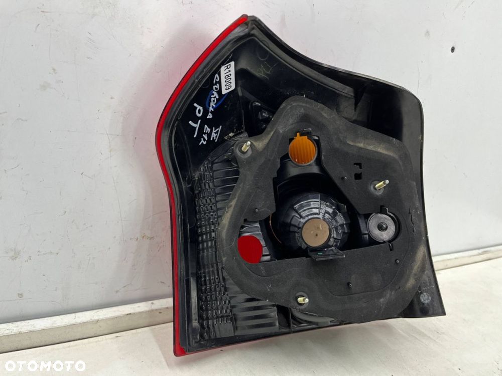 Lampa Toyota Corolla IX E12 HB hatchback LIFT 04-07r. prawa tylna w błotnik oryginalna prawy tył - 13