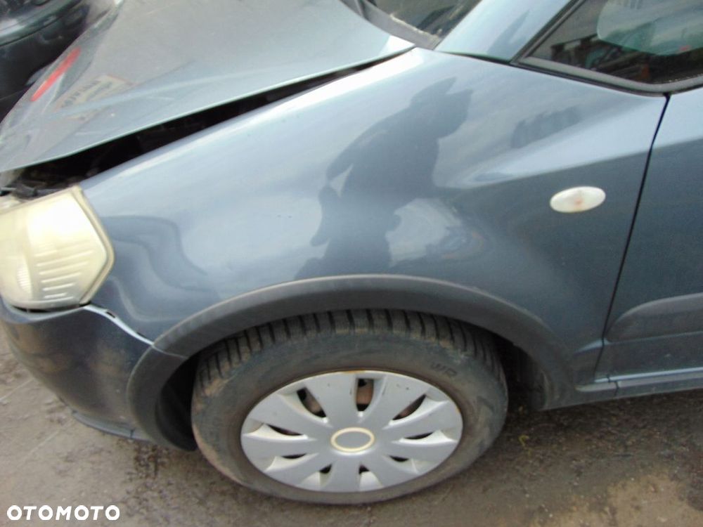BŁOTNIK LEWY PRZÓD PRZEDNI SUZUKI SX4 FIAT SEDICI ZY4 Z LISTWĄ - 1