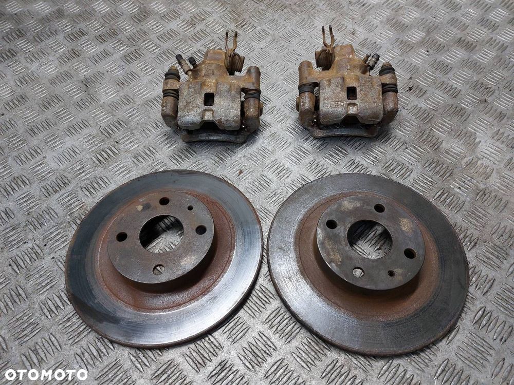 TARCZE HAMULCOWE TYŁ + KLOCKI + ZACISKI MAZDA 323F BJ 2.0 TD - 1