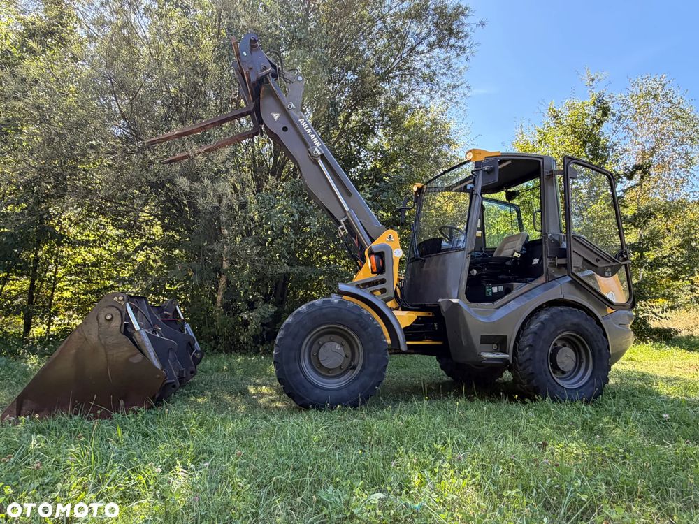 Mecalac AX1000 Ładowarka kołowa łamana 6,5 tony. Udźwig około 3 tony. 2017 rok.  Jak Nowa! Oryginał łyżka KROKODYL otwierana i widły. Mocny silnik DEUTZ 4 cylindry DEUTZ. Zero luzów i wycieków. Aktualne Badania DEKRA BMWT. Wielka Okazja. Maszyna jak nowa z Salonu. 2900 mtg. Pochodzi z Norweskiego urzędu gminy. Dodatkowe linie Hydrauliczne. Szybka wolna Jazda Rewers Hydrostatic. Wersja Norweska Mocne doświetlenie dodatkowe grzanie. kabina Ogrzewana wentylowana! Zmiana Osprzętu Hydrauliczna! pełne sterowanie z dżojstika! Podzespoły pompy suche, czytelne tabliczki! OKAZJA - 39