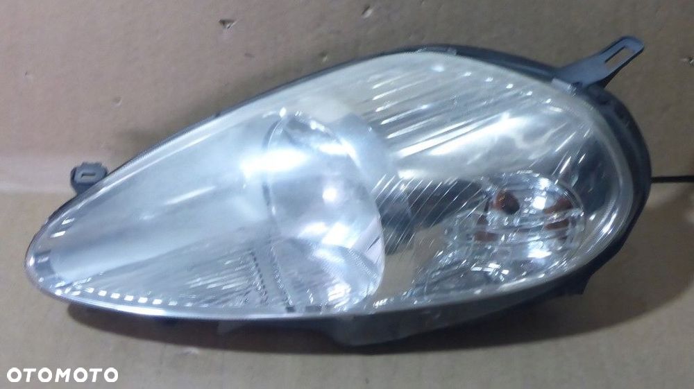 Fiat Grande Punto III Reflektor Lewy 89101387 - 1