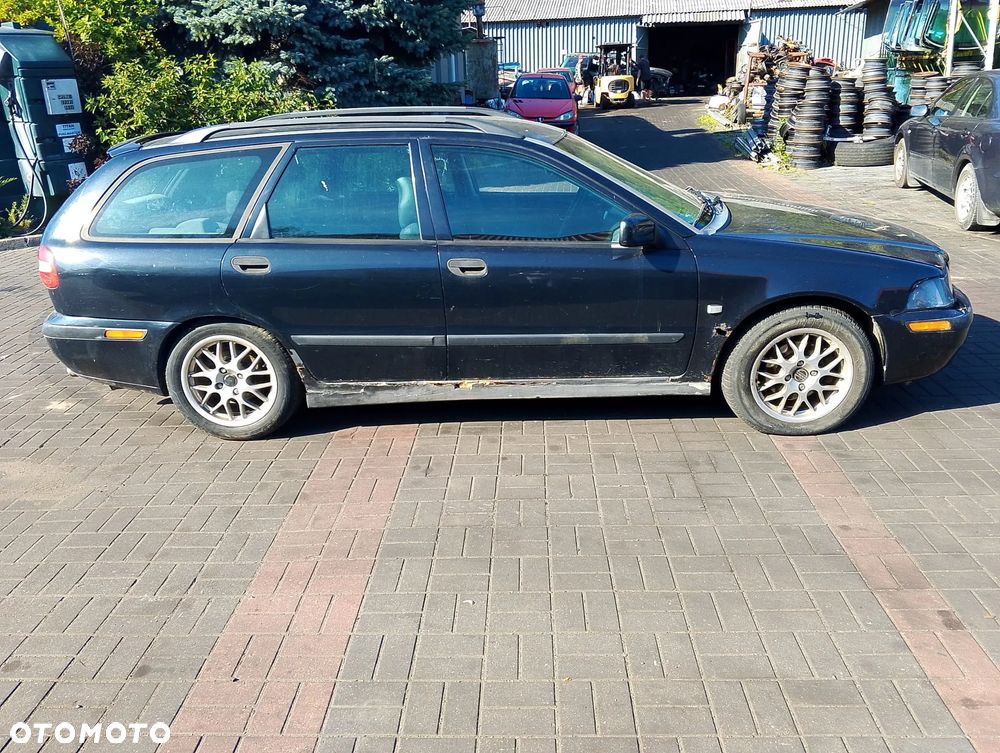 Volvo V40 I FL (99-04r.) 1.8 B 122KM. Silnik B4184S2 Skrzynia M5P lakier BLACK METALIC.Cały na części. GWARANCJA !!!  Przód Tył Zestaw Komplet Drzwi Klapa Zderzak Błotnik Maska Grill Atrapa Szyba Pas Lampa Lusterko Boczki Fotel Kanapa Kokpit Deska Rozdzielcza Przełącznik Włącznik Sterownik Przewody Wiązka Instalacja Moduł Komputer Czujnik Listwa Pompa Alternator Wtryski Głowica Rozrusznik Kompresor Sprzęgło Dwumas Silnik Skrzynia ABS Klimatyzacji Paliwa Wspomagania Kolektor Turbina Przepustnica Zawór Chłodnica Koło Hak Belka Sanki Zawieszenie Mcpherson Półoś Amortyzator Wydech Tłumik Zacisk Most - 5
