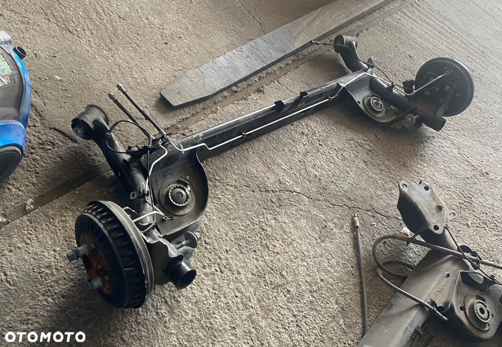 DACIA JOGGER SANDERO 3 III STEPWAY LOGAN III Nowa !!! 2025r PO 4,5 tys km! Igła! OŚ TYLNA BELKA ZAWIESZENIA TYŁ TYLNIA na bębnach bębny hamulec ręczny elektryczny elektryczne zaciski zawieszenie tylne  elektryka bębny ręczny elektryczny na przycisk Wwa - 2