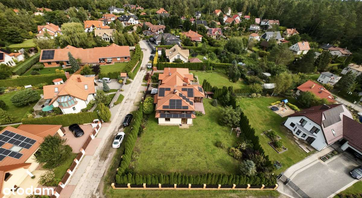 Dom nad jeziorem otulony lasem.