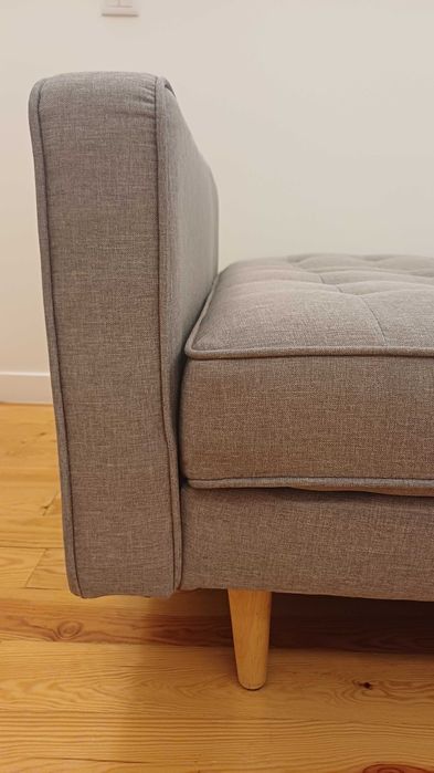 Sofa cama 3 lugares, cinzento claro, em tecido e pés de madeira. Sistema de abertura fácil clique clack. Marcas de uso identificadas na foto.