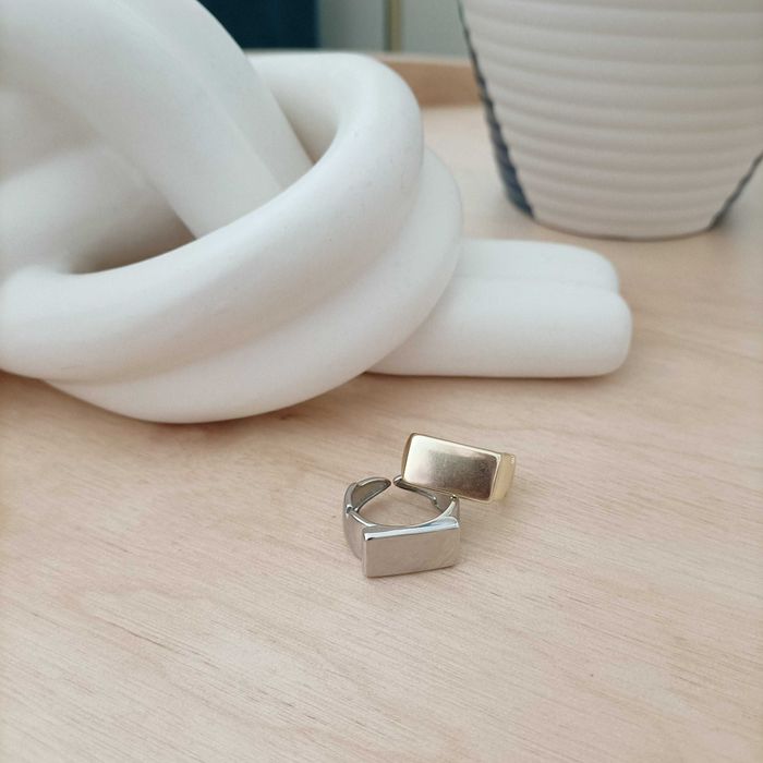 Conjunto de anéis em aço, um dourado e outro prateado.