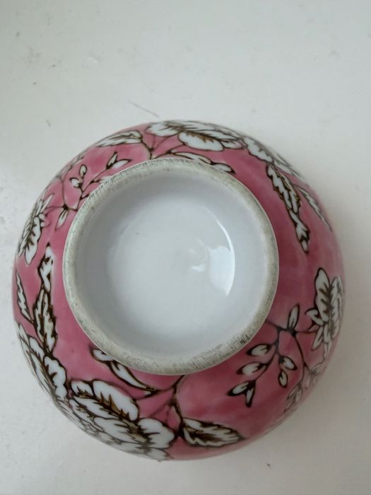 Esta é uma taça de chá cor-de-rosa com estampado de peónias.