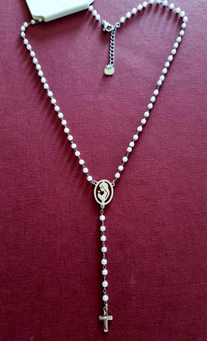 Colar prateado, em aço, em forma de terço com pequenas pérolas.