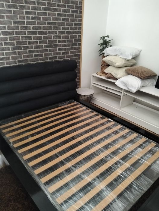 Uma cama casal com estrado e colchão