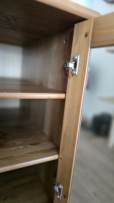 Móvel em pinho com portas de vidro e prateleiras