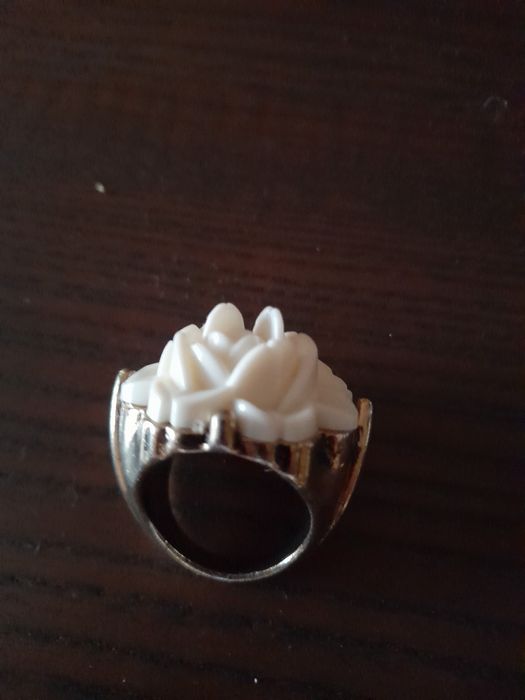 Anel dourado com uma grande flor em branco