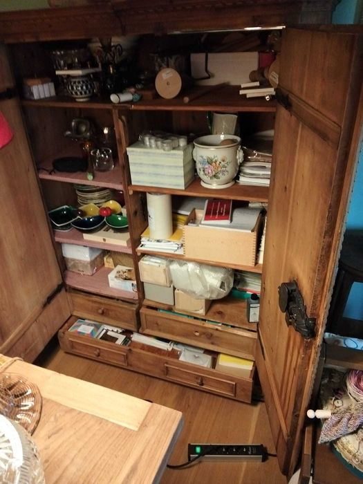 Armário com portas almofadadas e gavetas em madeira de pinho.