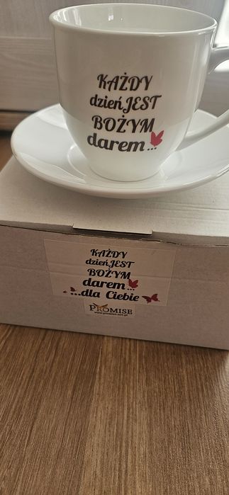 Biala porcelanowa filiżanka ze spodkiem  z napisem Każdy dzień jest Bożym darem