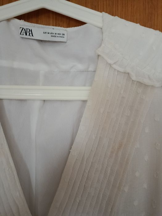 Vestido branco decote em V
Camada exterior com detalhes e folhos
Forro