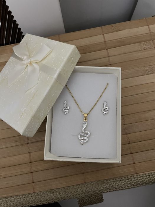 conjunto de colar e brincos dourados com simbolo de uma cobra