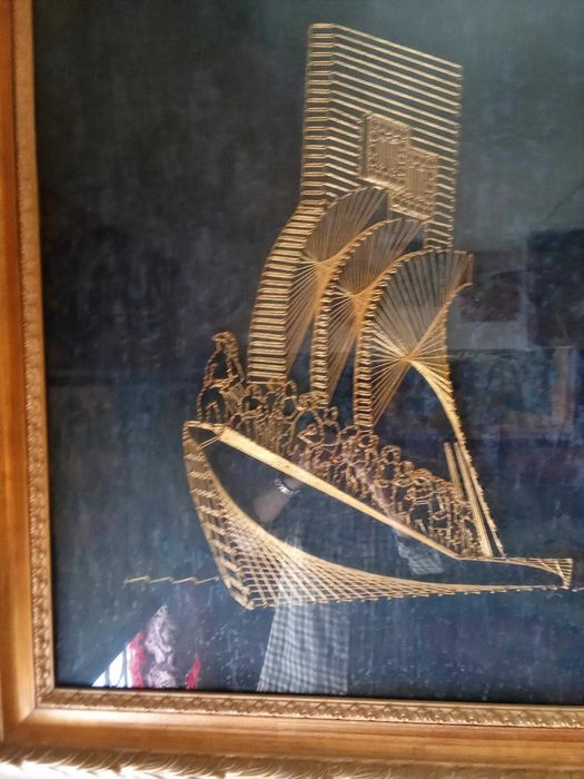 Quadro monumento aos descobrimentos construído com fio dourado.