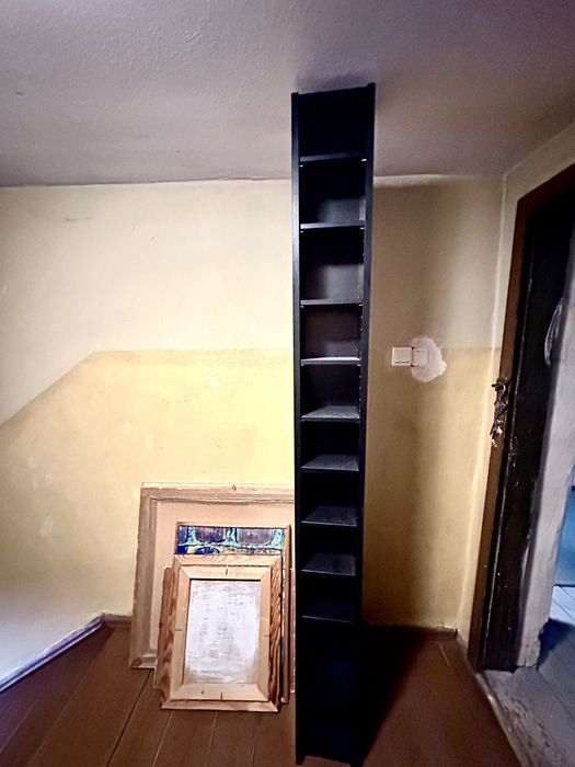 Wysoki i wąski, czarny regał na książki, płyty lub inne bibeloty