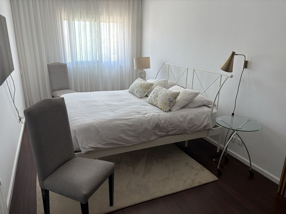 Quarto de casal com cama mesas e cadeiras