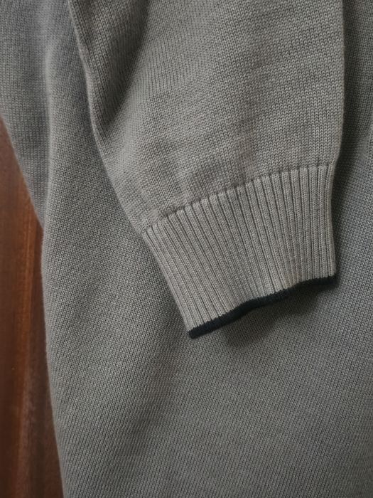 Polo de malha, de manga comprida.