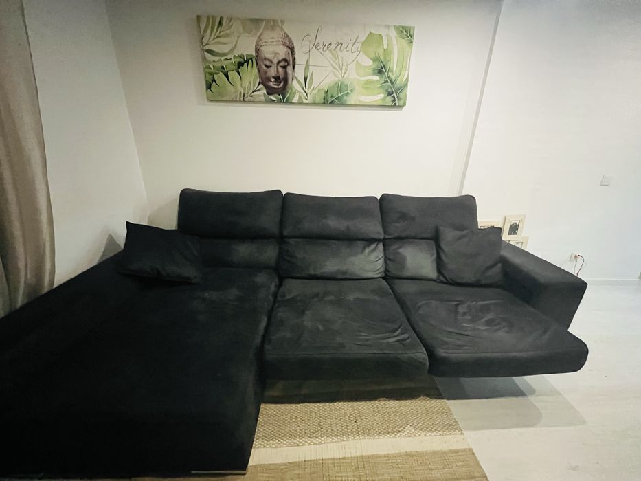 Sofá preto chaise longue, com arrumacão e 2 bancos