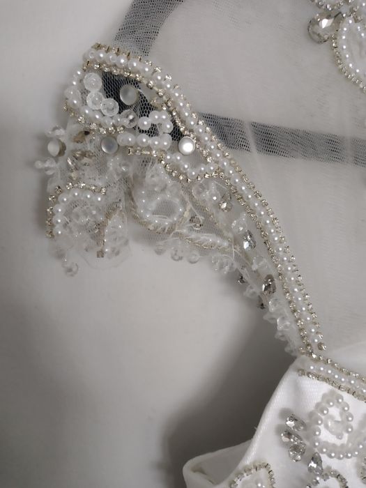 Suknia ślubna bogato zdobiona na lekkim rękawku