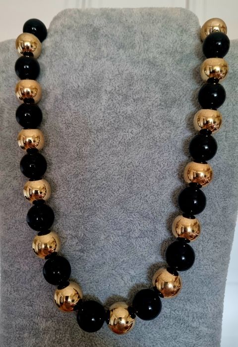 Colar dourado, em aço, às bolinhas douradas intercaladas com pretas. Leve.