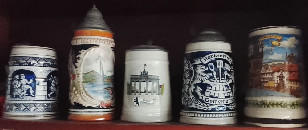 Cinco canecas, três com tampa de estanho.