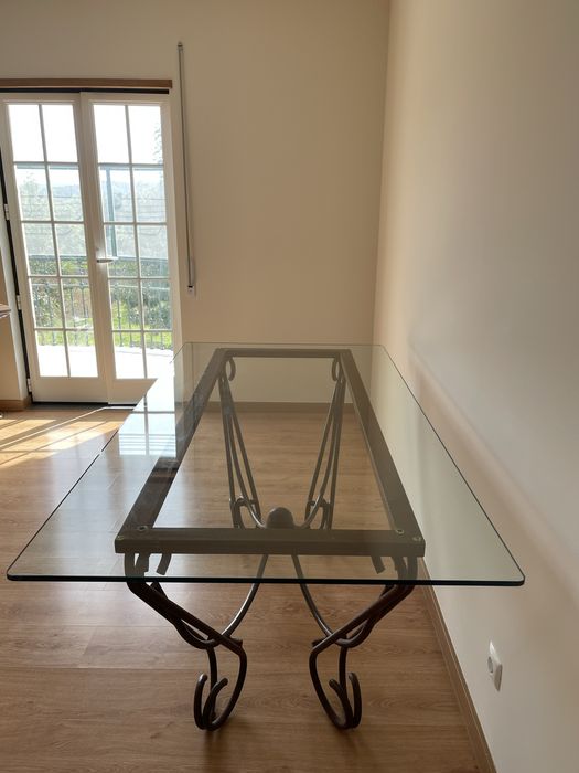 Mesa de jantar com tampo em vidro e base em ferro forjado