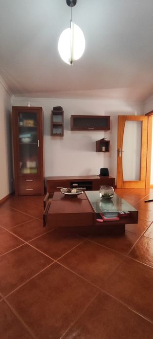 Sala completa com móveis de parede, TV, chão e centro.