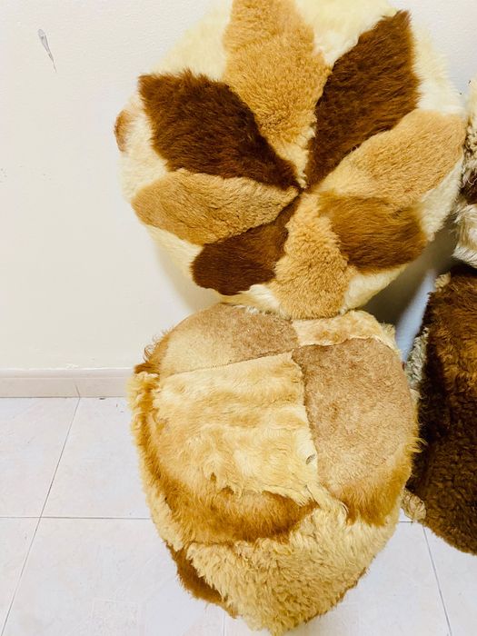 Dois puffes e duas almofadas em pêlo de carneiro