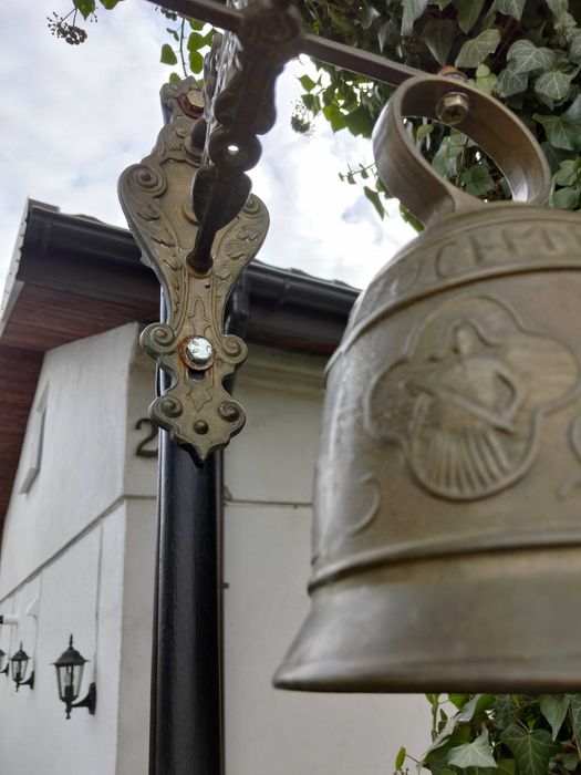 stary dzwon mosiężny , wiszący na stelażu