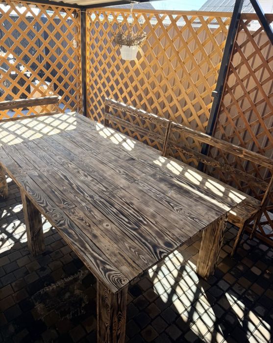 Деревянные лавки и большой стол в беседку