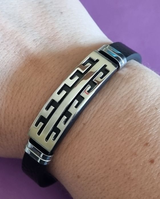 Pulseira de cabedal preto com peças prateadas em aço inoxidável.