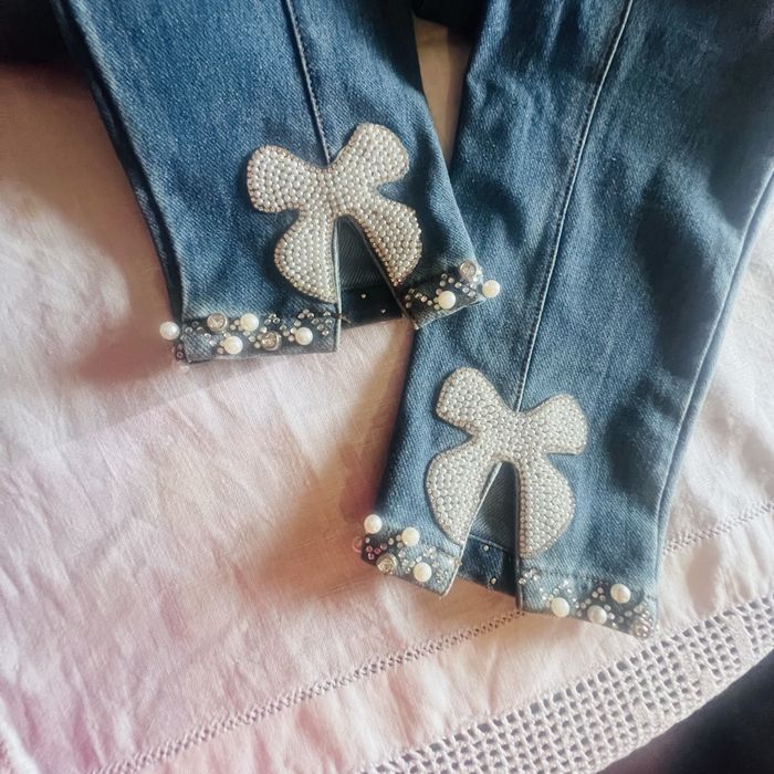 calça ganga com feitios de brilhantes