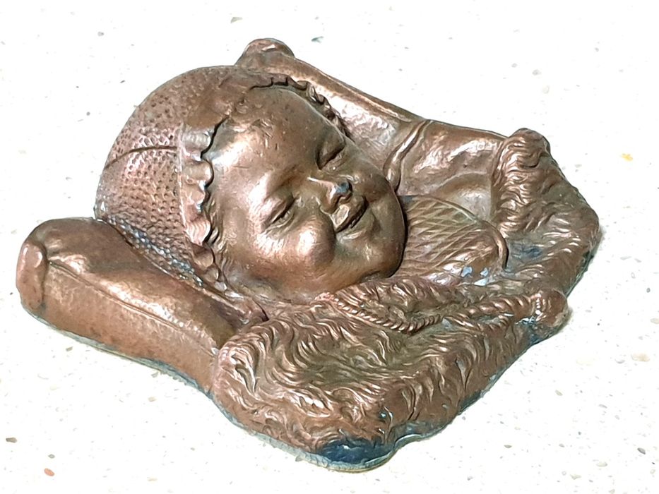 Amorosa antiga escultura de cabeça de um bebé à dormir numa almofada