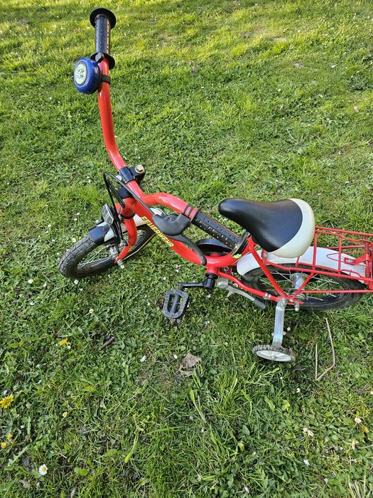 Rower czerwony z dostawionymi kółkami