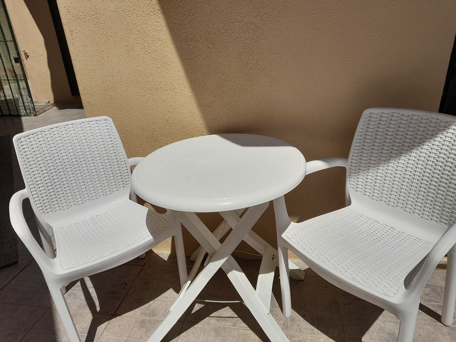 Mesa e cadeiras de jardim.