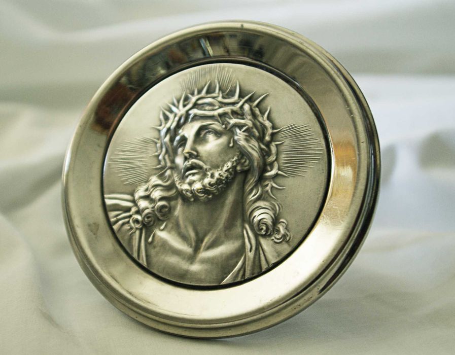 Medalhão em prata, com imagem de Cristo em baixo relevo, usado