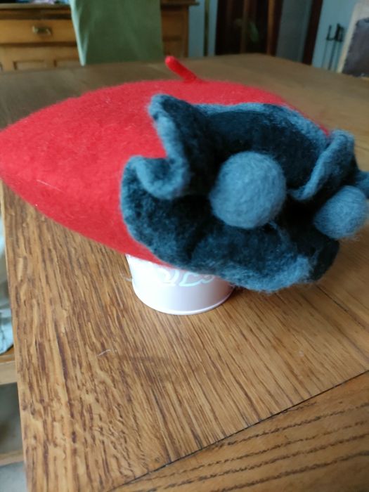 Nowy czerwony beret z kwiatami.