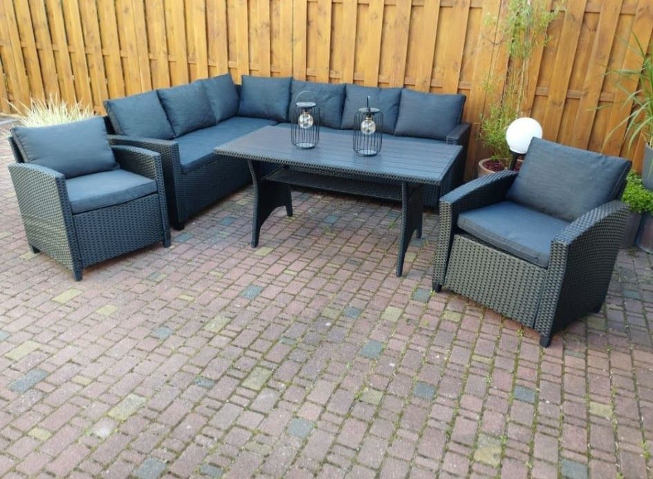 Narożnik z skrzyniami w siedziskach stół i dwa fotele.