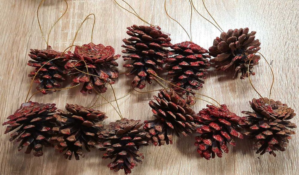 Набір ялинкових іграшок з 11 шишок у червоних блискітках.