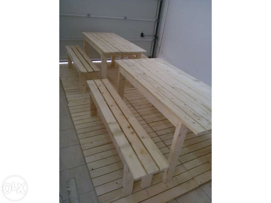 Vários conjuntos de mesas e bancos corridos.